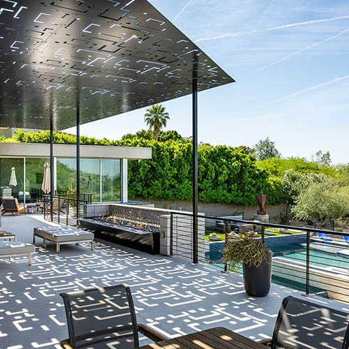 Patterned aluminum shade panels above a poolside terrace